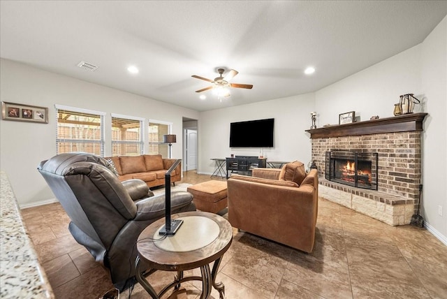 living room with ceiling fan and a brick fireplace