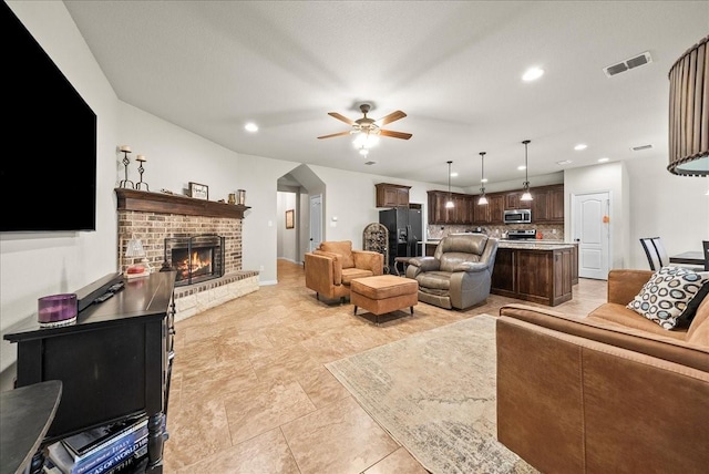 living room with a fireplace and ceiling fan