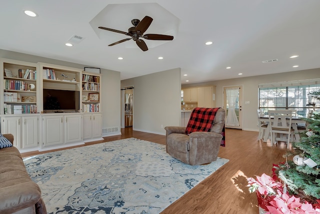 living room with ceiling fan and light wood-type flooring