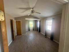 unfurnished room featuring dark hardwood / wood-style flooring, ceiling fan, plenty of natural light, and vaulted ceiling