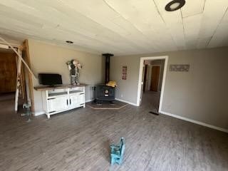 unfurnished living room with dark hardwood / wood-style flooring and a wood stove