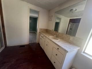 bathroom with a shower with door, vanity, and wood-type flooring