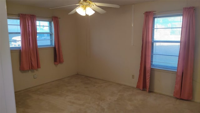 unfurnished room with light colored carpet and ceiling fan