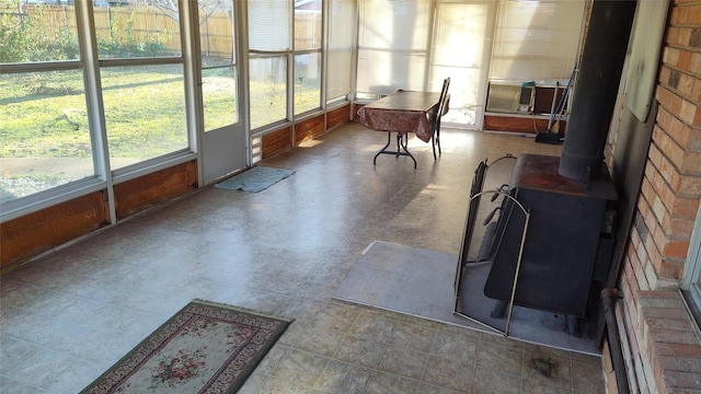 sunroom / solarium with cooling unit, a healthy amount of sunlight, and a wood stove