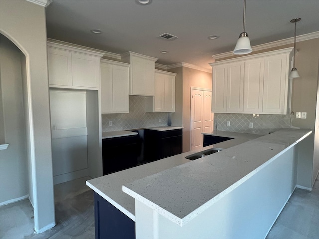 kitchen featuring kitchen peninsula, decorative backsplash, decorative light fixtures, and white cabinetry