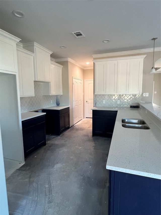 kitchen featuring backsplash, crown molding, white cabinets, and decorative light fixtures