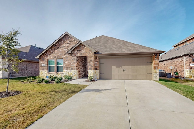 view of front of property with a front yard, a garage, and central air condition unit