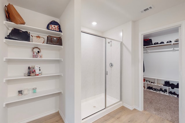 bathroom featuring hardwood / wood-style floors and an enclosed shower