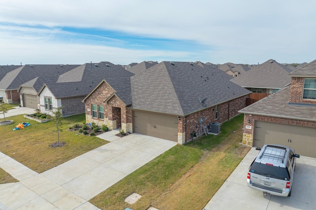 view of front of home featuring central air condition unit, a front yard, and a garage