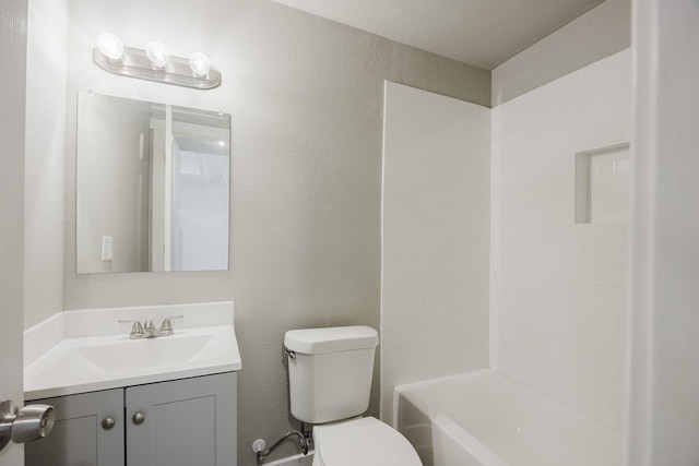 bathroom featuring toilet, a textured wall, shower / tub combination, and vanity