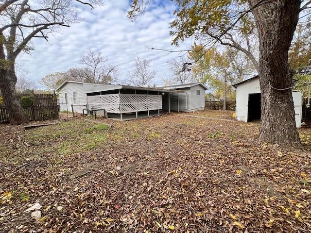 back of property with an outdoor structure and a carport