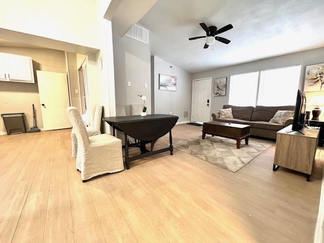 living room featuring light wood-type flooring, ceiling fan, and lofted ceiling