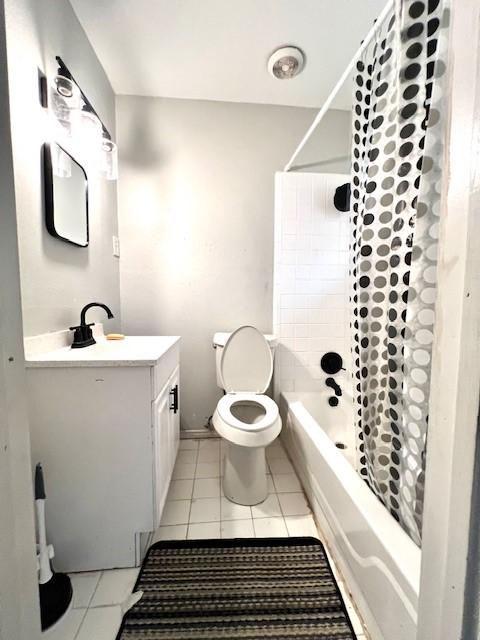 full bathroom with toilet, vanity, tile patterned floors, and shower / bath combo with shower curtain