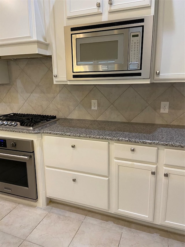 kitchen with tasteful backsplash, dark stone countertops, and stainless steel appliances