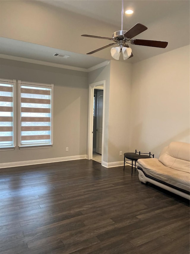 interior space with ceiling fan, dark wood-type flooring, and ornamental molding