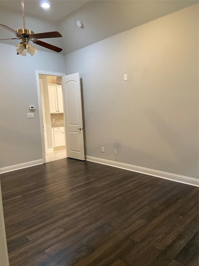 spare room with lofted ceiling, ceiling fan, and dark wood-type flooring