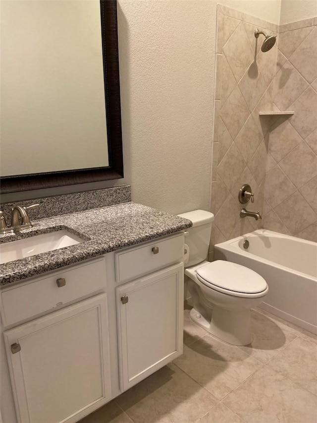 full bathroom with toilet, vanity, tile patterned floors, and tiled shower / bath