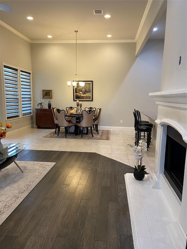 living room featuring light hardwood / wood-style floors, crown molding, and a notable chandelier