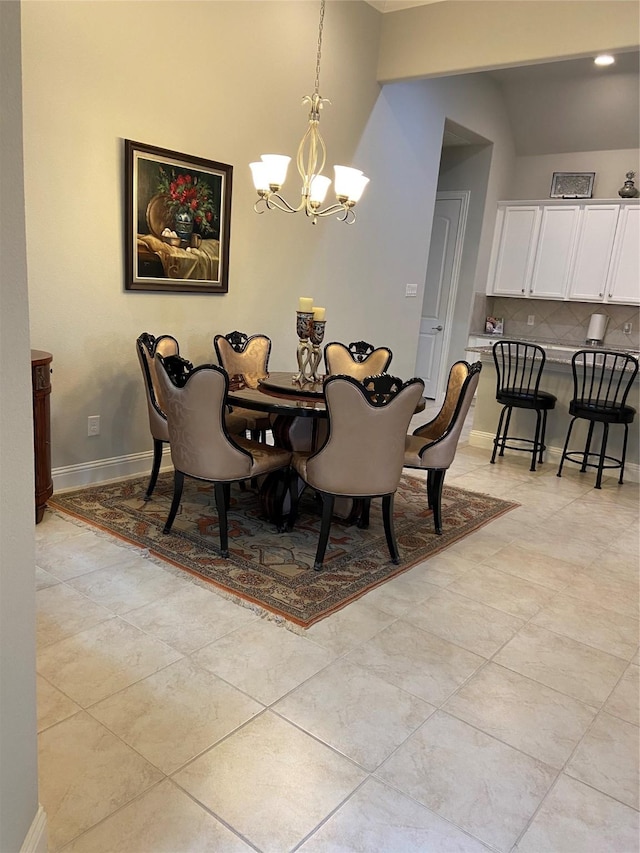 tiled dining space with vaulted ceiling and an inviting chandelier