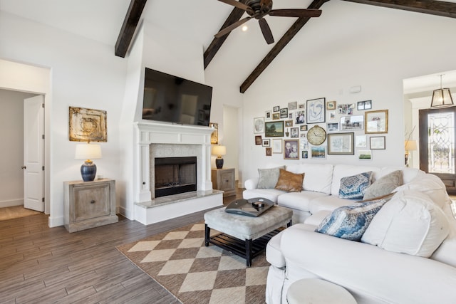 living room featuring ceiling fan, hardwood / wood-style floors, high vaulted ceiling, and beamed ceiling