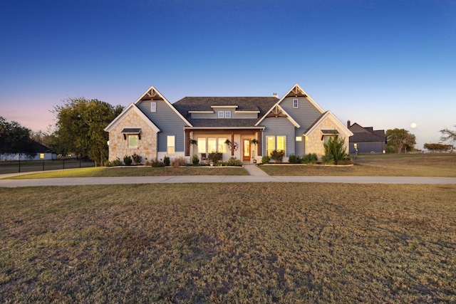 craftsman-style house with a porch and a lawn