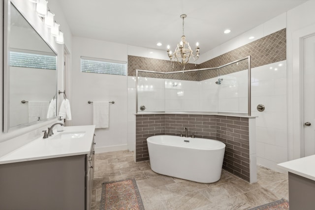 bathroom with a chandelier, vanity, independent shower and bath, and tile walls