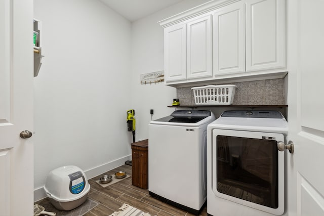 washroom with washer and dryer, dark hardwood / wood-style flooring, and cabinets