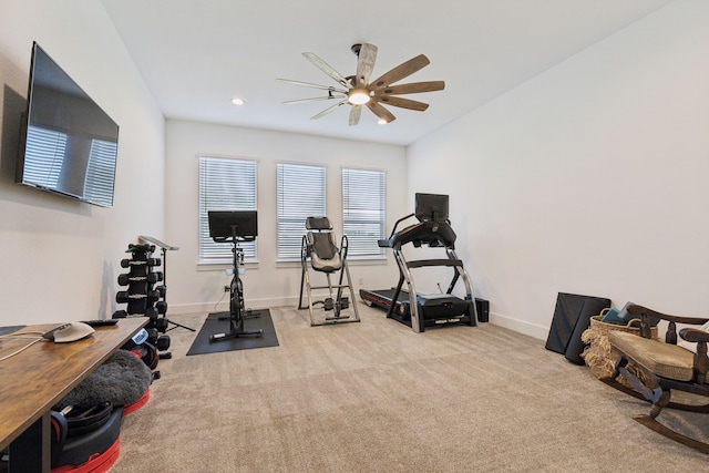 exercise room with ceiling fan and light carpet