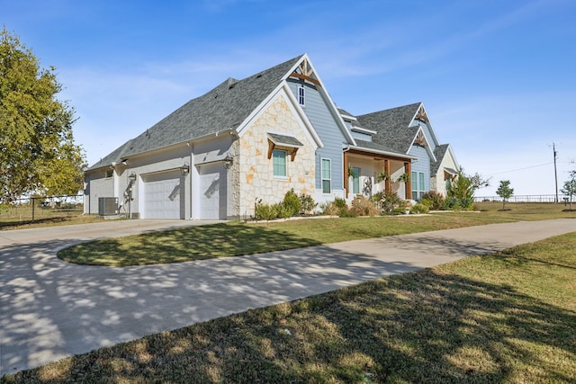 view of front facade featuring central air condition unit, a front yard, and a garage