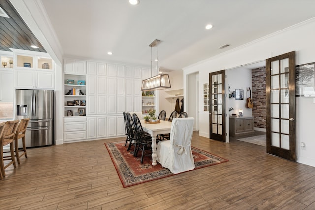 dining area with french doors, dark wood-type flooring, and ornamental molding