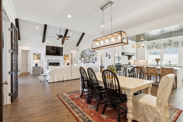 dining room featuring vaulted ceiling with beams, dark hardwood / wood-style floors, sink, and ceiling fan