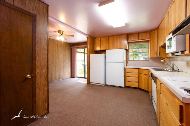 kitchen with dark colored carpet, ceiling fan, white appliances, and sink