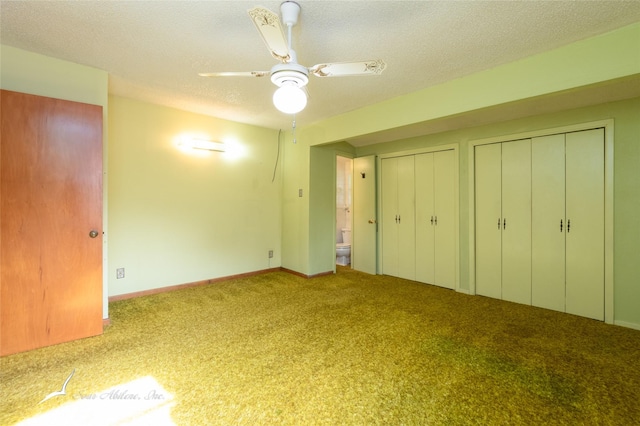 unfurnished bedroom with multiple closets, ceiling fan, light carpet, and a textured ceiling