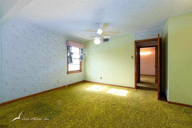 spare room with ceiling fan, carpet, and a textured ceiling