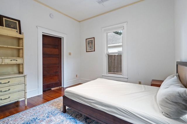 bedroom featuring crown molding, dark wood-type flooring, and a closet