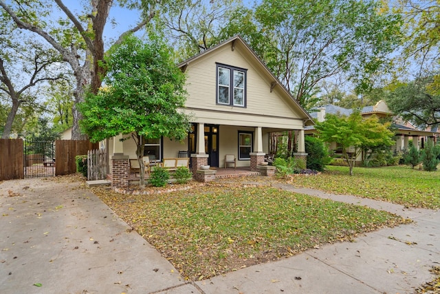 bungalow with covered porch and a front lawn