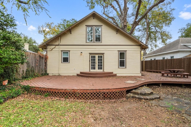 rear view of property featuring french doors and a wooden deck