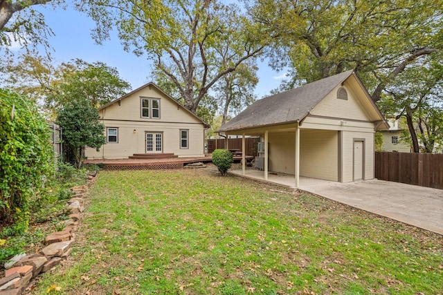 back of property with a patio, a wooden deck, and a lawn