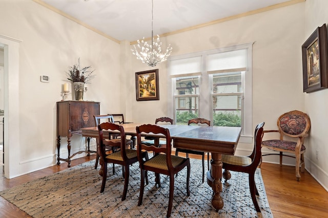 dining space featuring hardwood / wood-style flooring, a notable chandelier, and ornamental molding