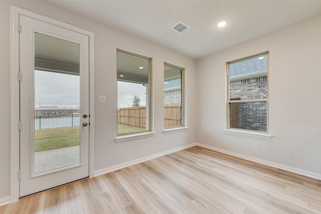 doorway to outside with a water view and light wood-type flooring