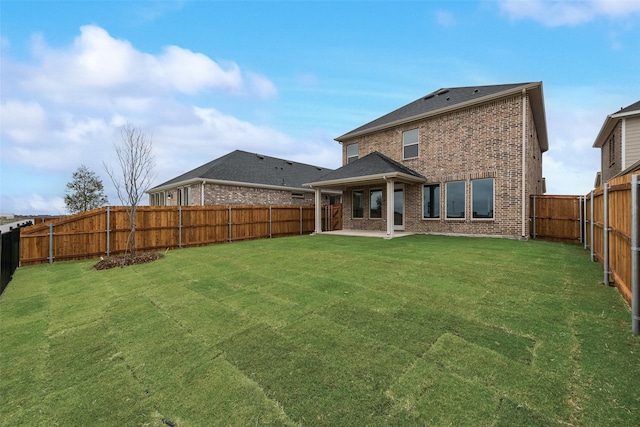 back of house featuring a lawn and a patio area