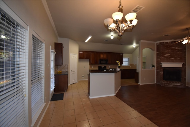 kitchen featuring pendant lighting, a brick fireplace, range with electric stovetop, and ornamental molding