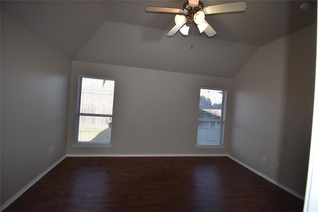 unfurnished room featuring lofted ceiling, a wealth of natural light, and dark hardwood / wood-style flooring