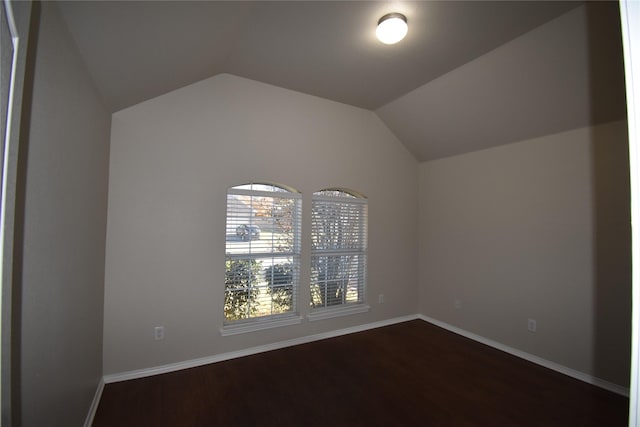 empty room with lofted ceiling and dark hardwood / wood-style flooring