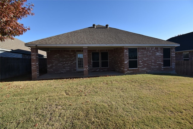 rear view of property with a lawn and a patio