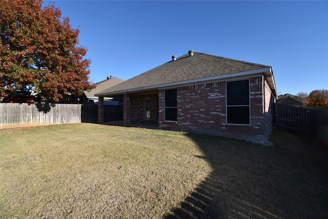 rear view of property featuring a yard