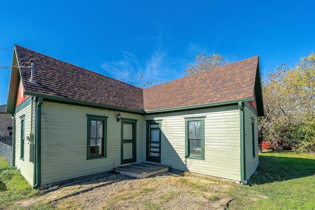 rear view of house featuring a lawn