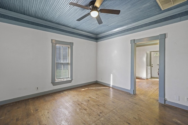 spare room with hardwood / wood-style floors, ceiling fan, and a raised ceiling