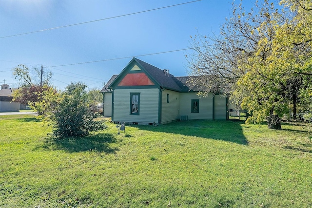 back of house featuring a lawn and central AC