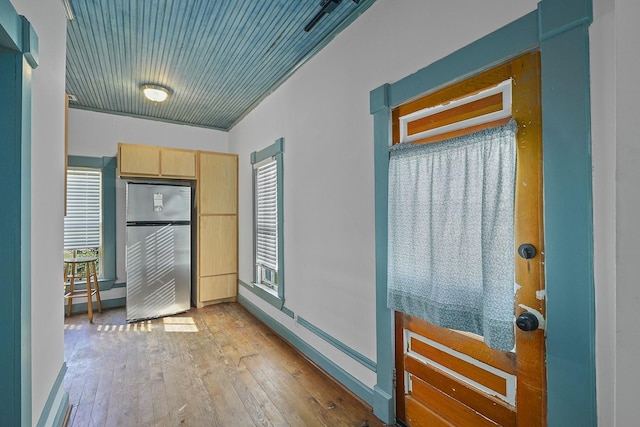 interior space featuring stainless steel fridge, light brown cabinetry, light hardwood / wood-style flooring, and plenty of natural light